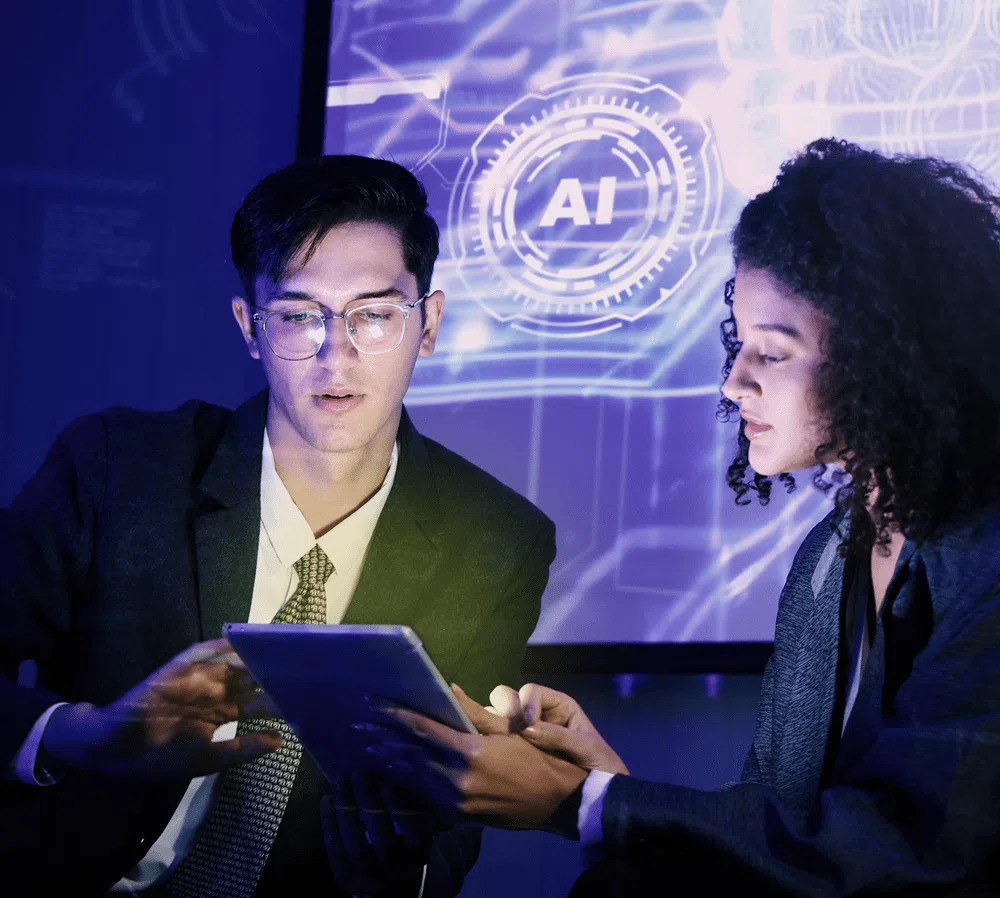 Two professionals collaborating on a tablet with AI interface displayed on screen in a modern office setting