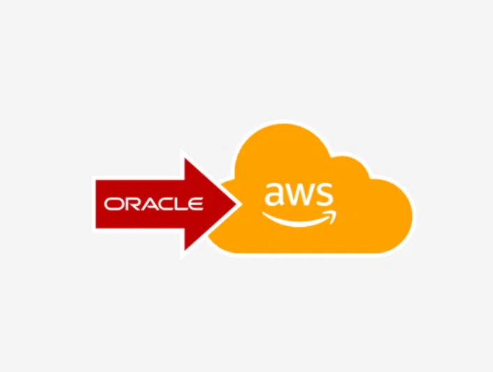 A simple graphic on a light gray background showing a red arrow pointing to the right with the word “Oracle” inside it in white text. The arrow points toward an orange cloud shape labeled “aws” in white lowercase letters with the curved smile logo beneath. The layout visually suggests a transition or migration from Oracle to AWS (Amazon Web Services).