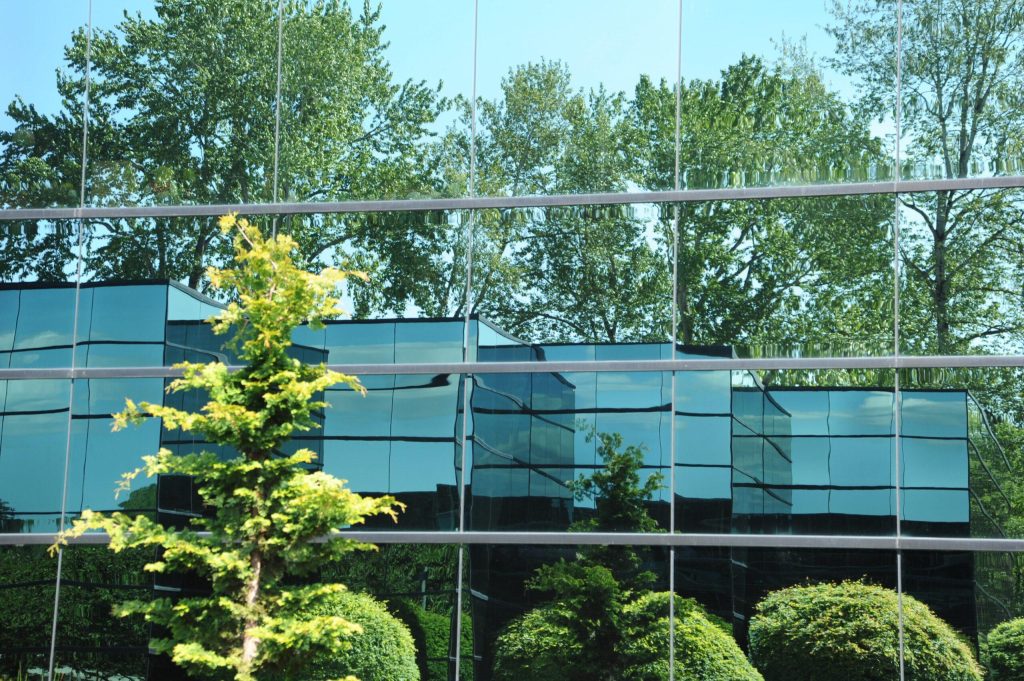 modern building with trees reflected in mirrored walls