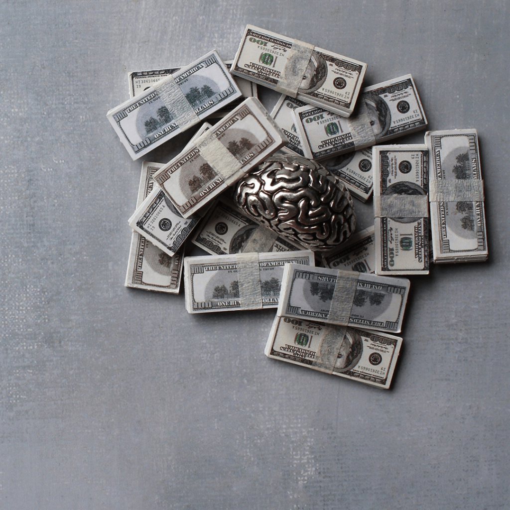 metallic brain surrounded by money