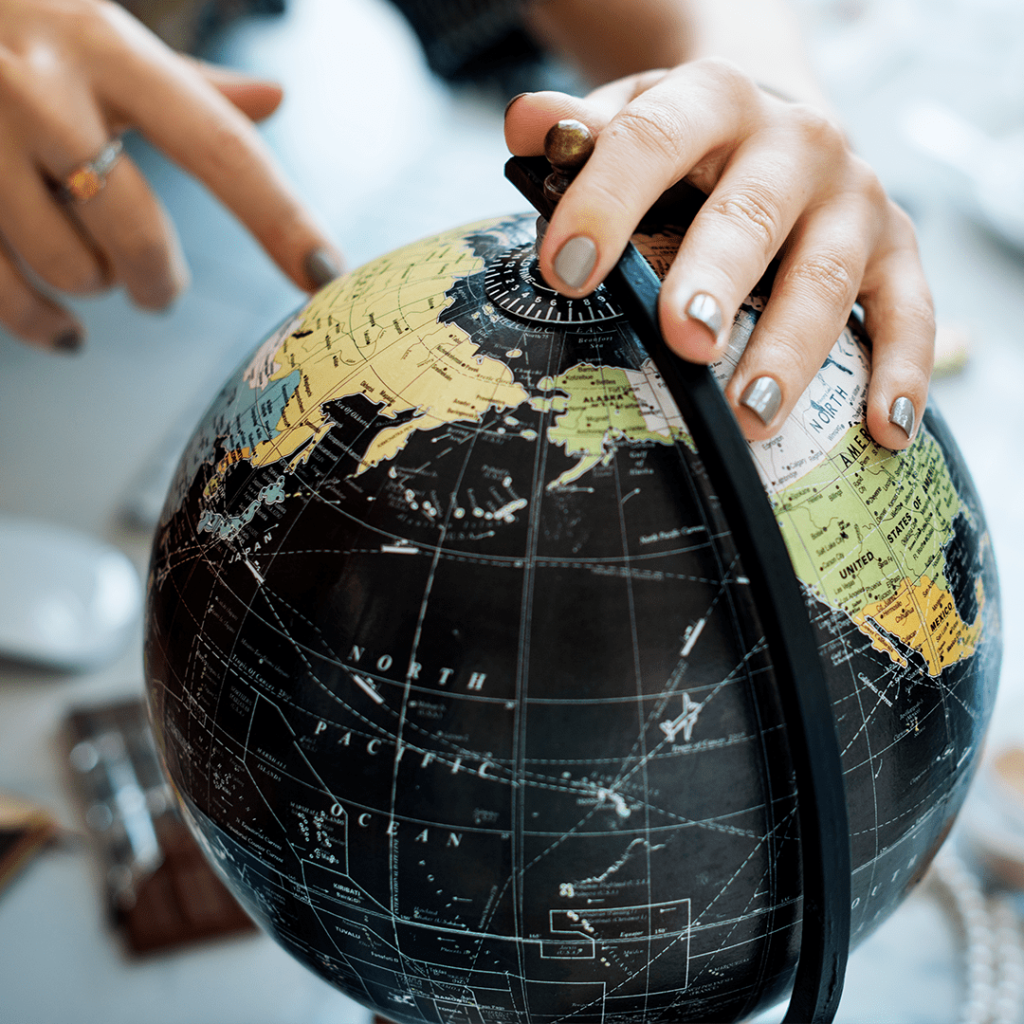 Globe with a person pointing at a location