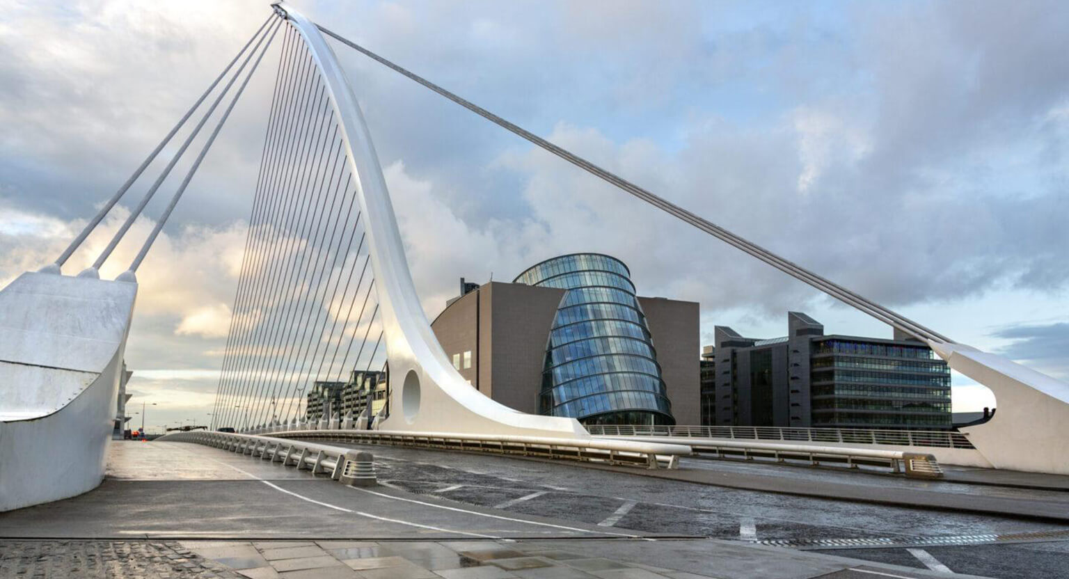 The Samuel Beckett Bridge and the building on the waterfront near the Convention Center - Dublin city center in the Republic of Ireland. This is a cable-stayed bridge that joins Sir John Rogerson's Quay on the south side of the River Liffey to Guild Street and North Wall Quay in the Docklands area. The innovative architect Santiago Calatrava designed this and a number of other bridges and buildings in Ireland.
