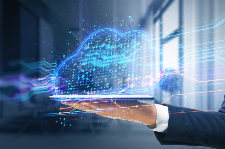 The image depicts a futuristic representation of cloud computing in a modern office-like setting, where a hand in a dark business suit sleeve is extended palm-up in the foreground, appearing to present a glowing, semi-transparent cloud hologram hovering just above it; the cloud is formed by numerous interconnected dots, lines, and particles in bright blue and cyan tones, giving it a digital, network-like structure, while streams of light extend outward from the cloud toward the right side, symbolizing data flow or high-speed information transfer, and the softly blurred background features large window panels with diffused natural light, creating a clean, professional atmosphere enhanced by cool color tones, smooth gradients, and a polished, high-tech aesthetic that visually communicates ideas of digital transformation, cloud storage, connectivity, and modern data-driven services.