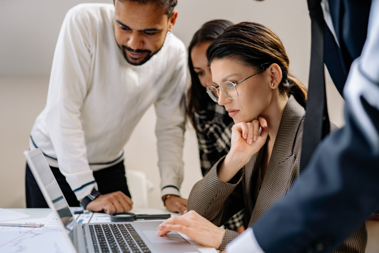 Three people looking at a laptop