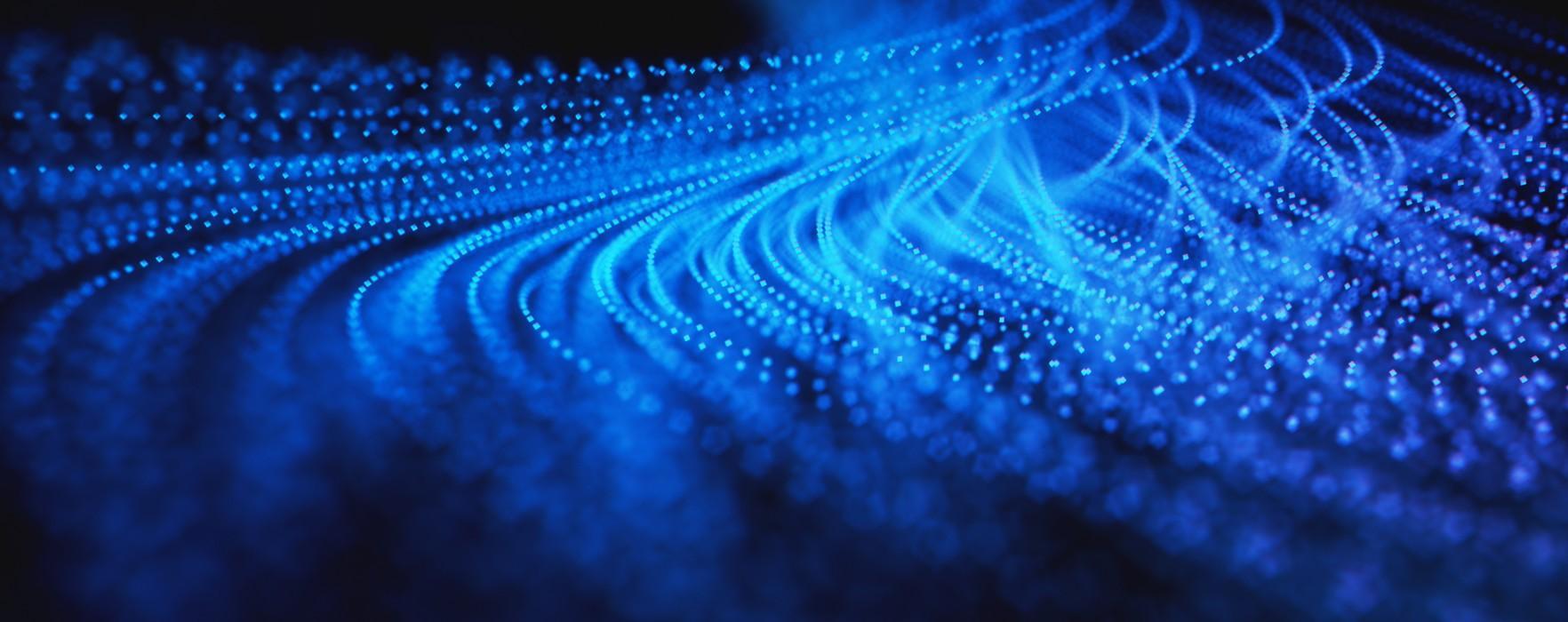 Abstract digital background of glowing blue particles arranged in flowing, wave-like patterns, resembling data streams or neural networks against a dark backdrop.
