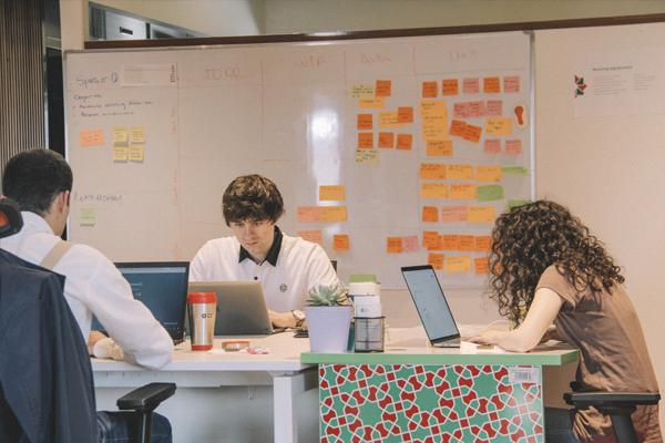Three people at laptops