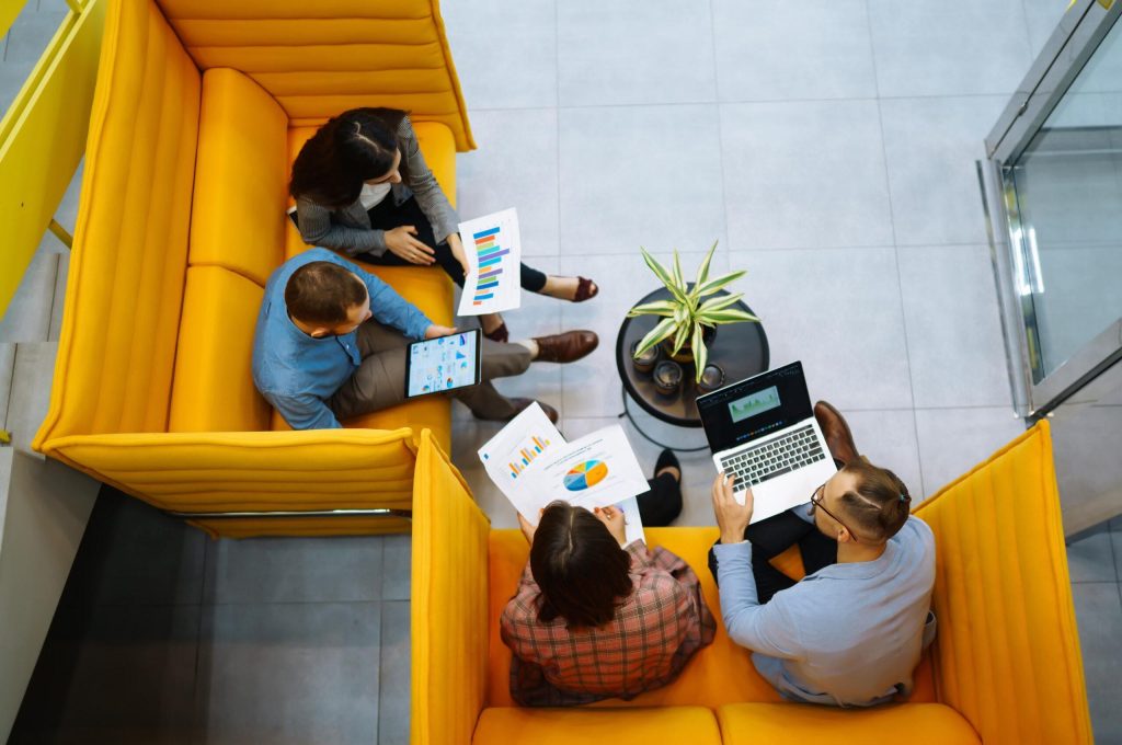 Group of young people sitting together with laptops