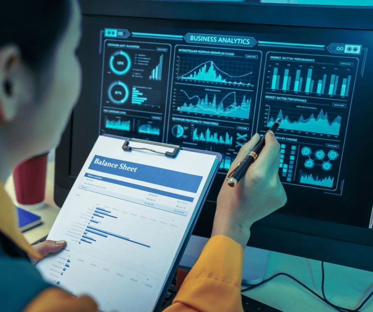 An Asian businesswoman analyzes digital charts on a computer screen, reviewing performance reports